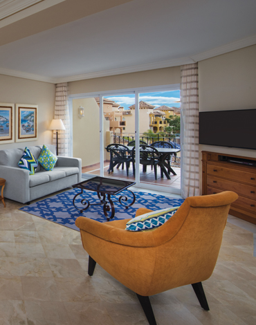 Interior of a spacious villa with sofa, armchair, and blue area rug